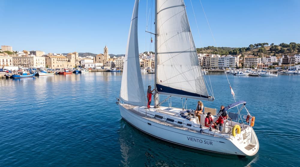 Pequeños veleros navegando con el viento El Puerto de Santa María en aguas tranquilas de la Bahía de Cádiz.