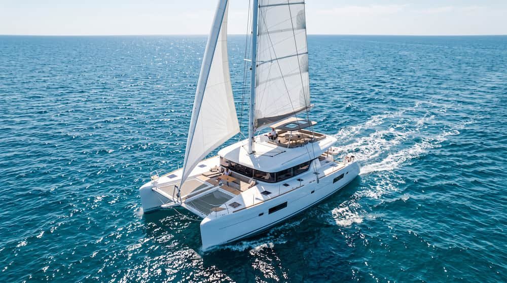 Catamarán moderno navegando en aguas tranquilas disfrutando de un día de navegación a vela.