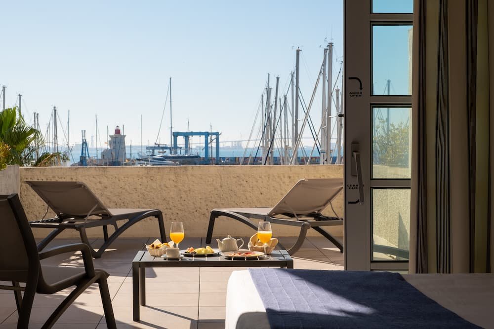 Hotel suite terrace with sun loungers and breakfast served overlooking the yachts at Puerto Sherry marina.